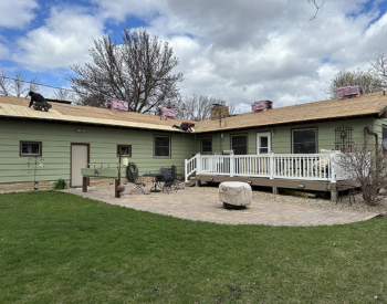 Residential home with green siding and a partially completed roof installation, highlighting roofing services available in Minnetonka.