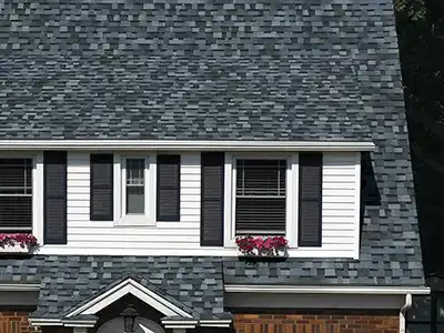 Close up of a residential roof with gray shingles that are darker or lighter